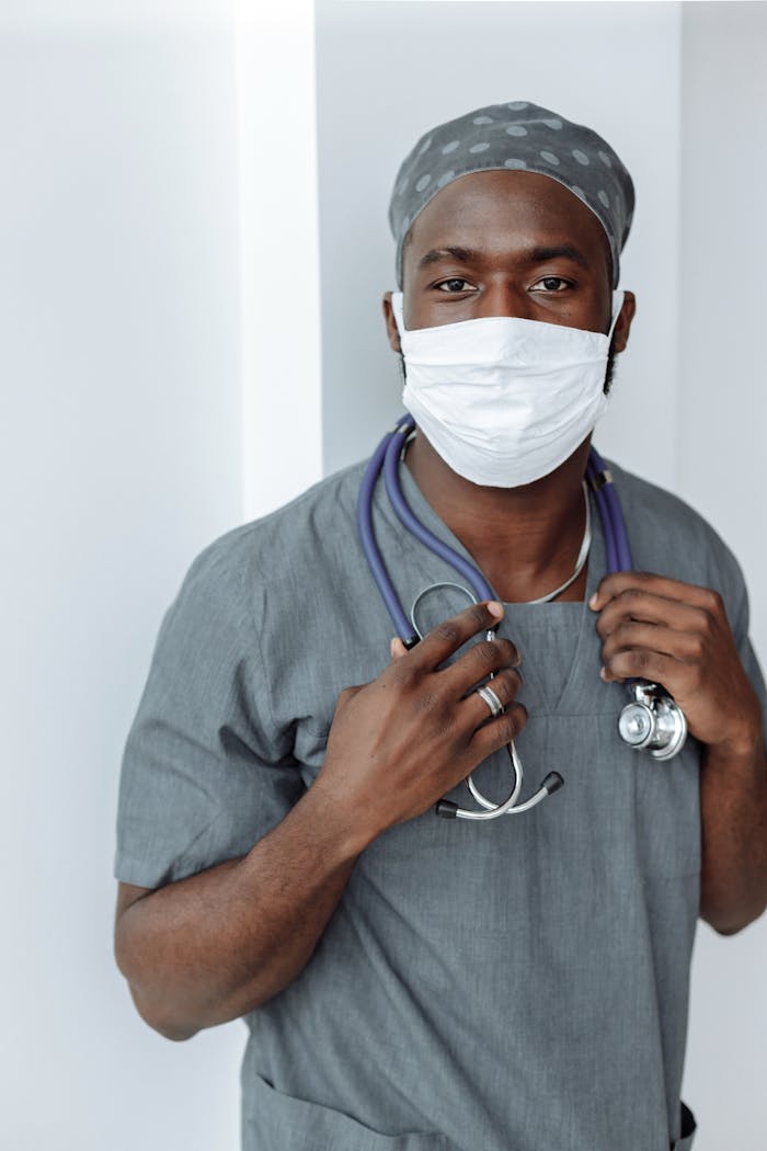 About Portrait of a healthcare worker wearing a face mask and scrubs, demonstrating COVID-19 safety measures.
