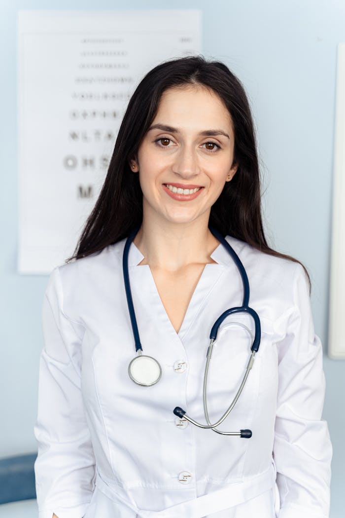 About Smiling female doctor with stethoscope in a clinic setting. Warm, professional ambiance.