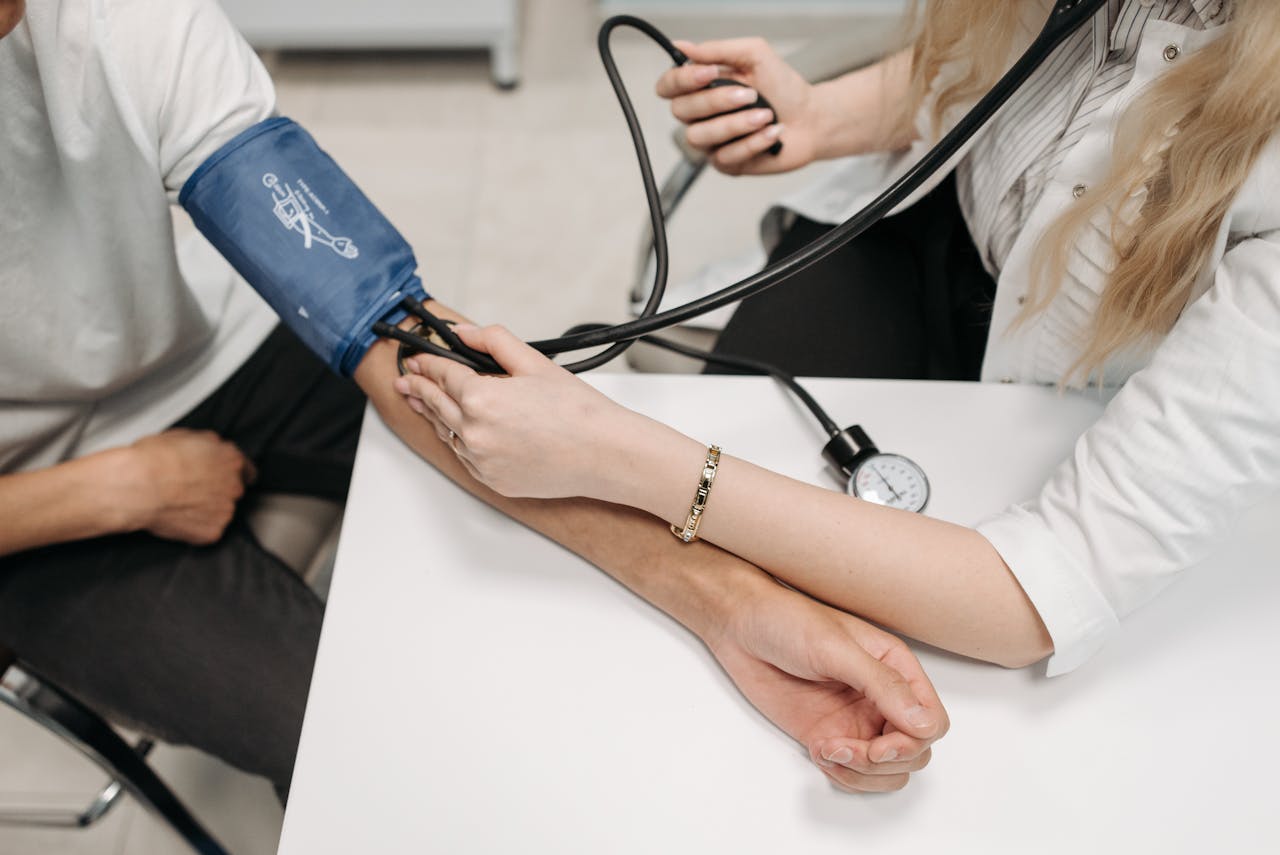 Services A doctor measures a patient's blood pressure with a sphygmomanometer during a consultation.